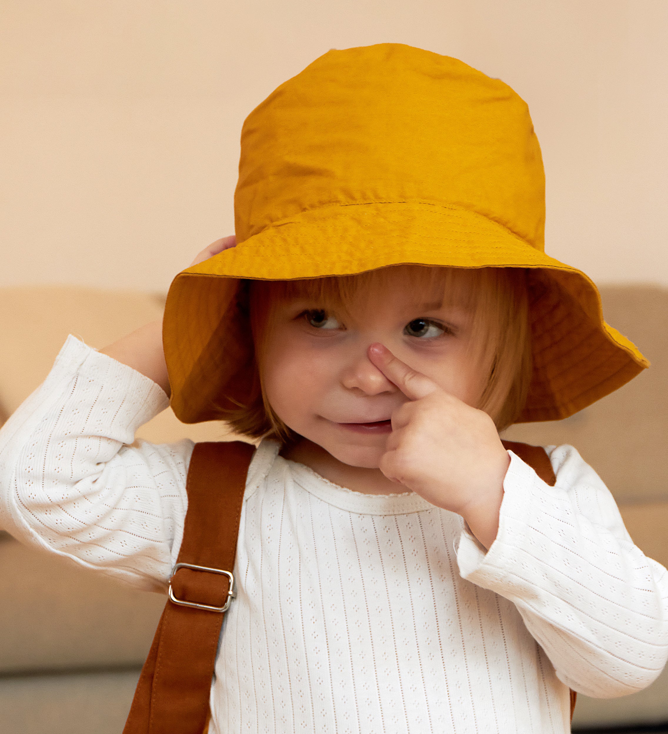 A child wearing the golden yellow Tiger bucket hat from Roommate. 