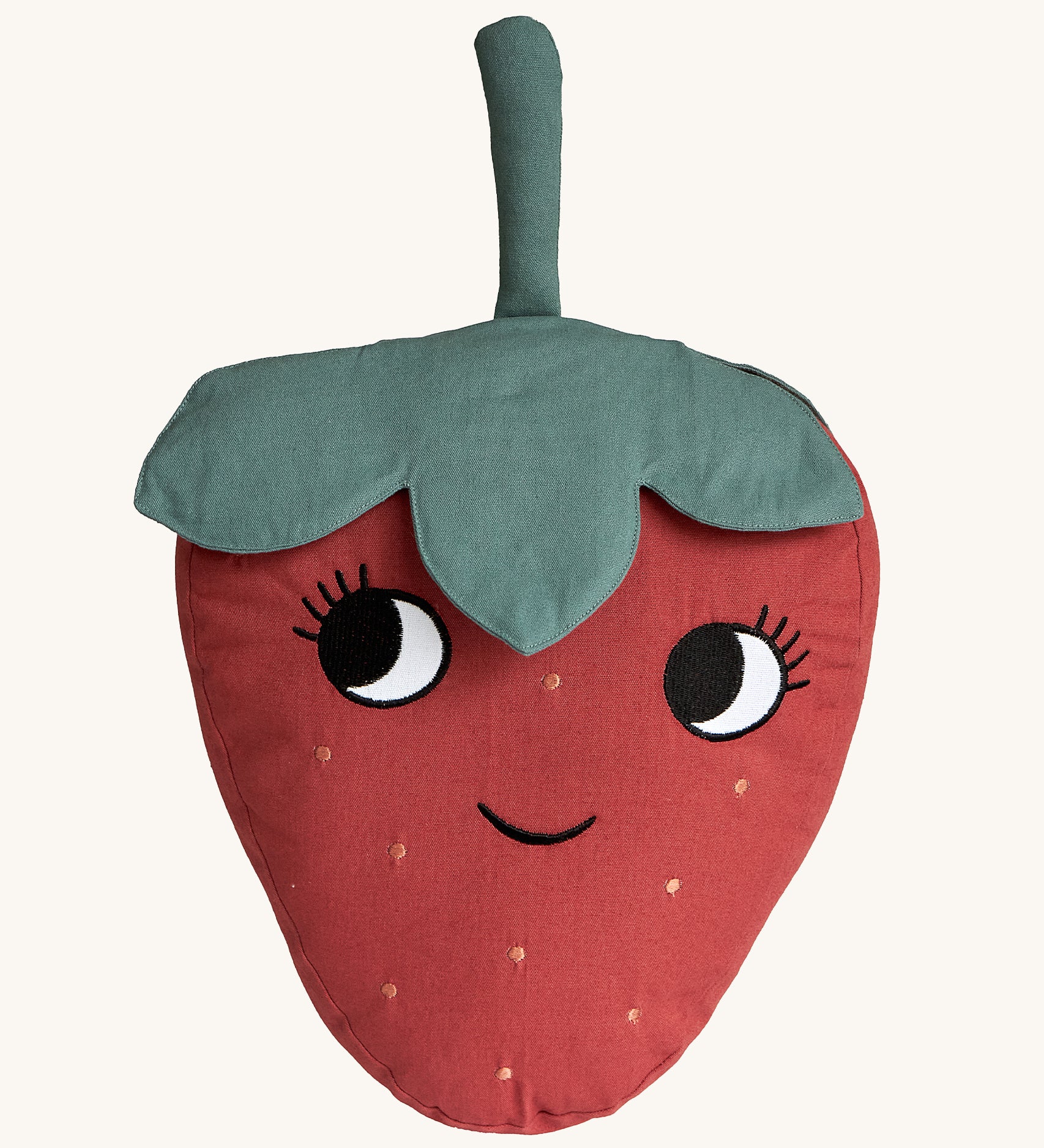 Roommate Organic Cotton Strawberry Cushion. A fun, soft Strawberry cushion with a red fruit body with big eyes and a smiling mouth, and green leafy top on a cream background