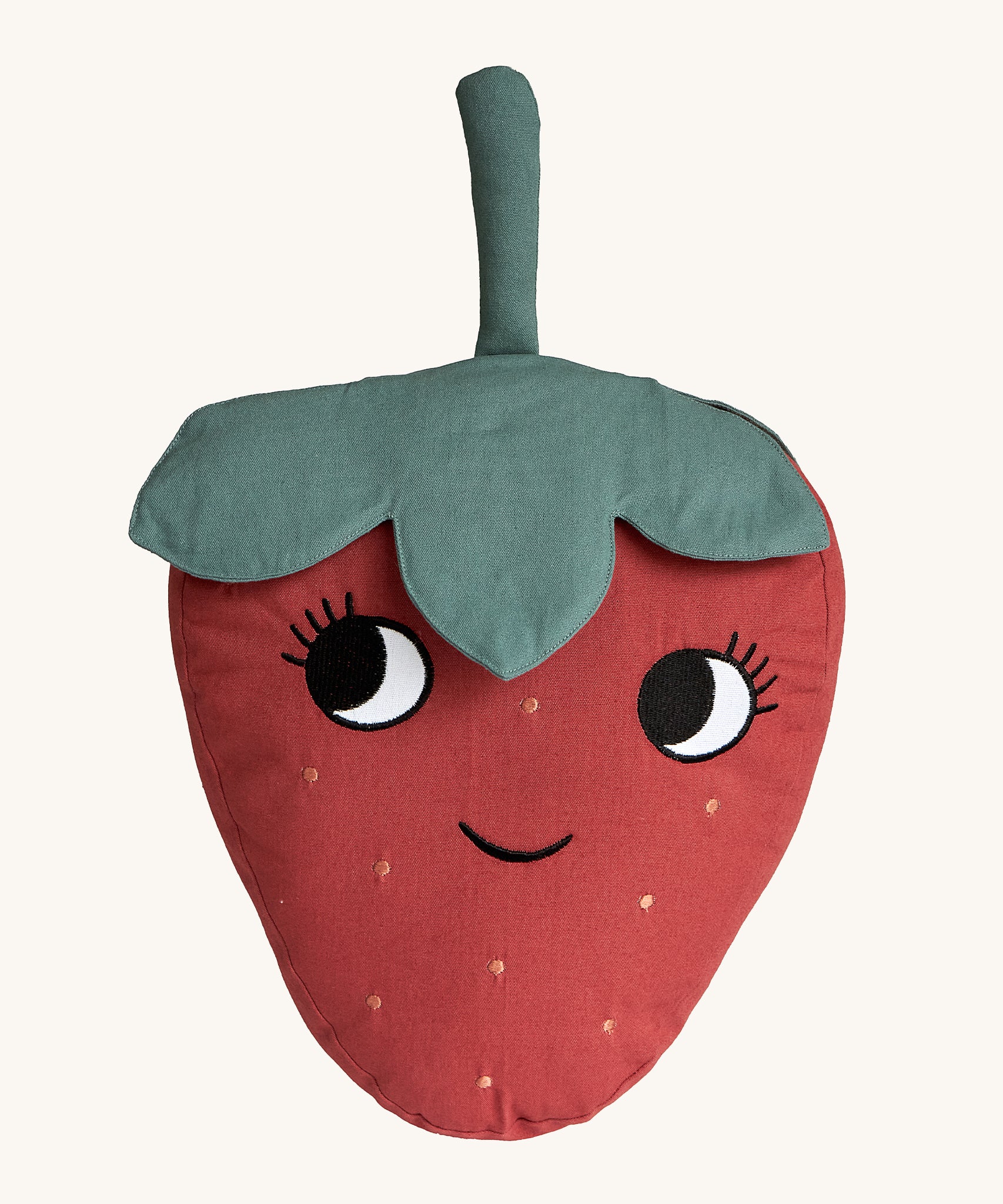 Roommate Organic Cotton Strawberry Cushion. A fun, soft Strawberry cushion with a red fruit body with big eyes and a smiling mouth, and green leafy top on a cream background