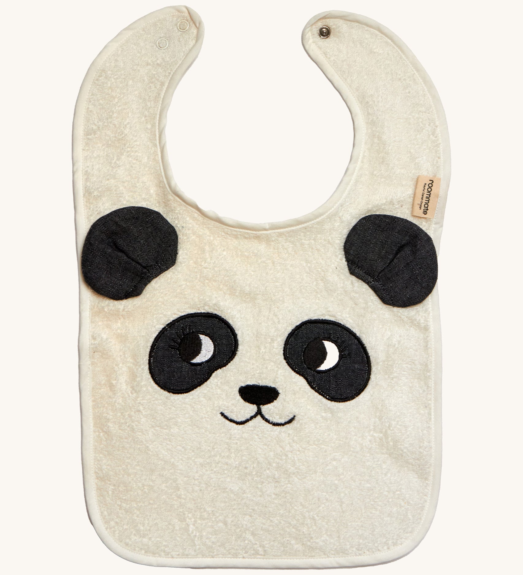 The Roommate Panda Baby Bib in organic cotton with embroidered panda face with 3D ears. Cream background.