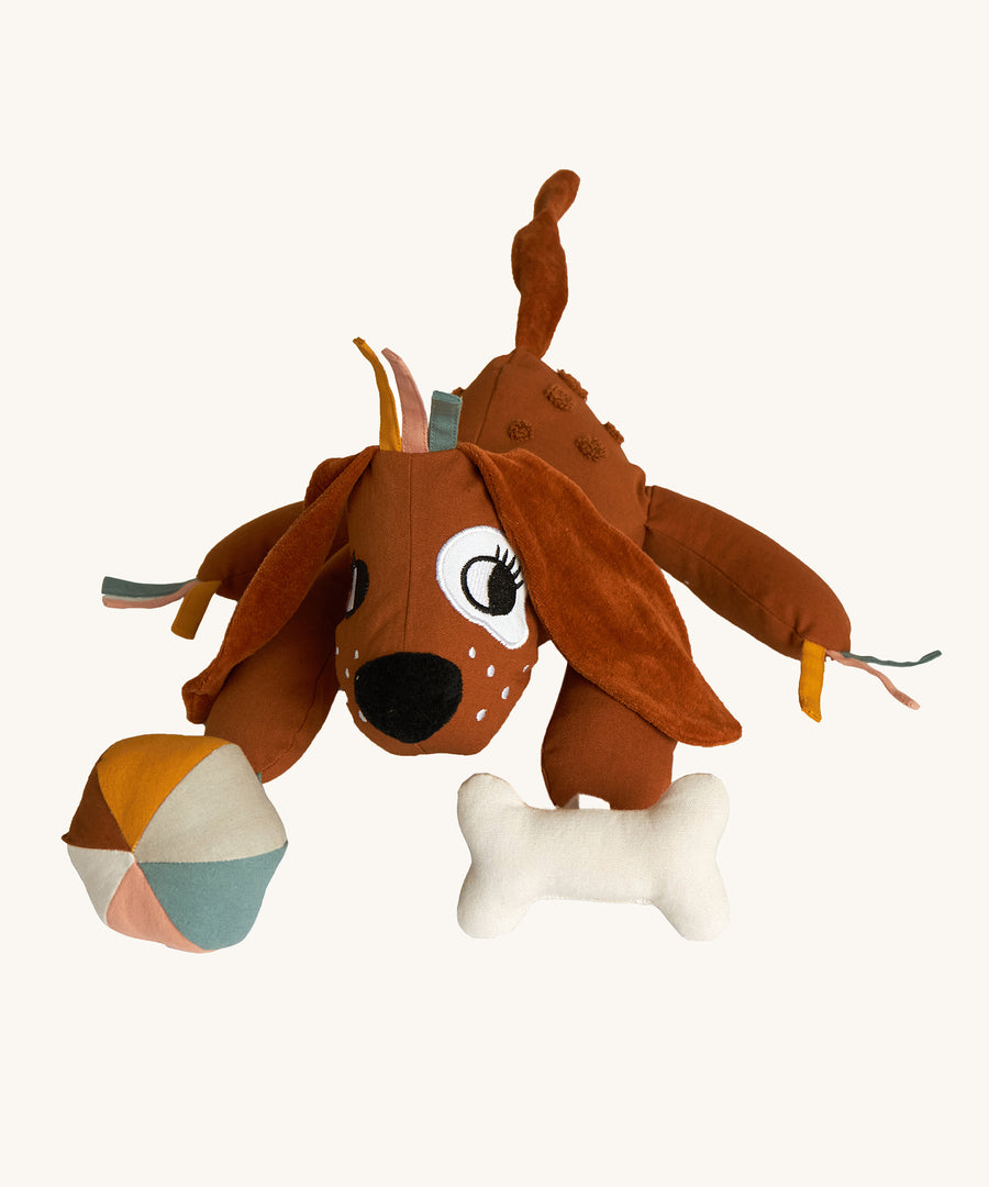 Roommate Activity Dog toy with a cute embroidered face, big soft floppy ears, and toy attachments. Designed with fun details for tiny fingers to fiddle with. This product has many different textures and sounds