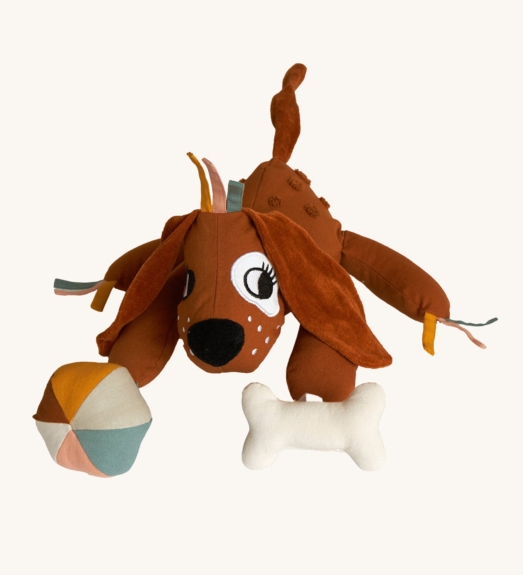 Roommate Activity Dog toy with a cute embroidered face, big soft floppy ears, and toy attachments. Designed with fun details for tiny fingers to fiddle with. This product has many different textures and sounds