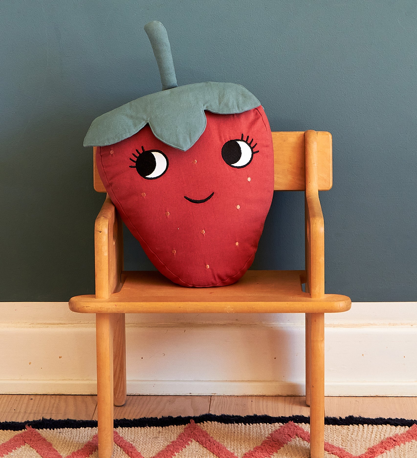  soft Strawberry cushion with a red fruit body with big eyes and a smiling mouth