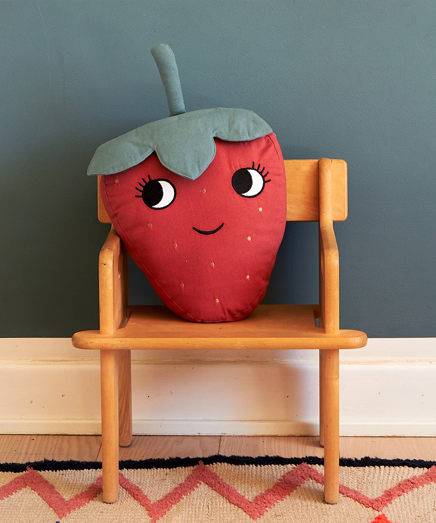  soft Strawberry cushion with a red fruit body with big eyes and a smiling mouth