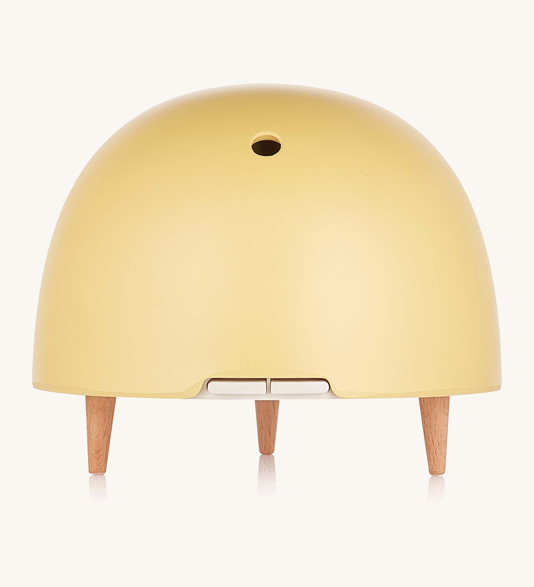 Maël Diffuser, a light yellow dome plug-in essential oil diffuser with wooden feet. 