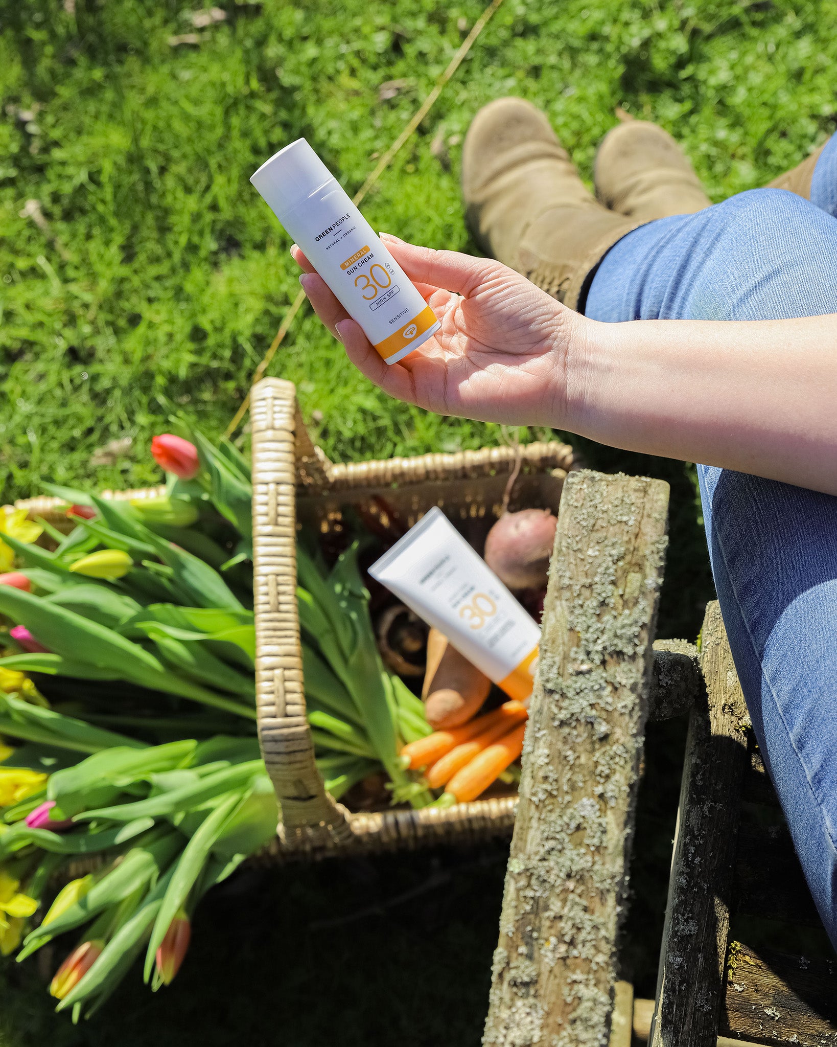 A person holding the Green People Natural and Organic Mineral Suncream SPF30 Scent Free bottle in their hand