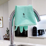 Close up of some Seep turquoise rubber household gloves draped over a silver tap