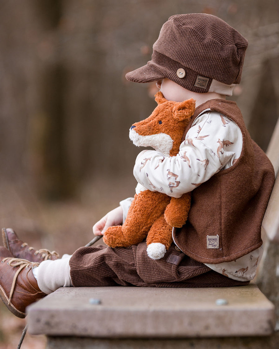 A child sitting on a bench outside