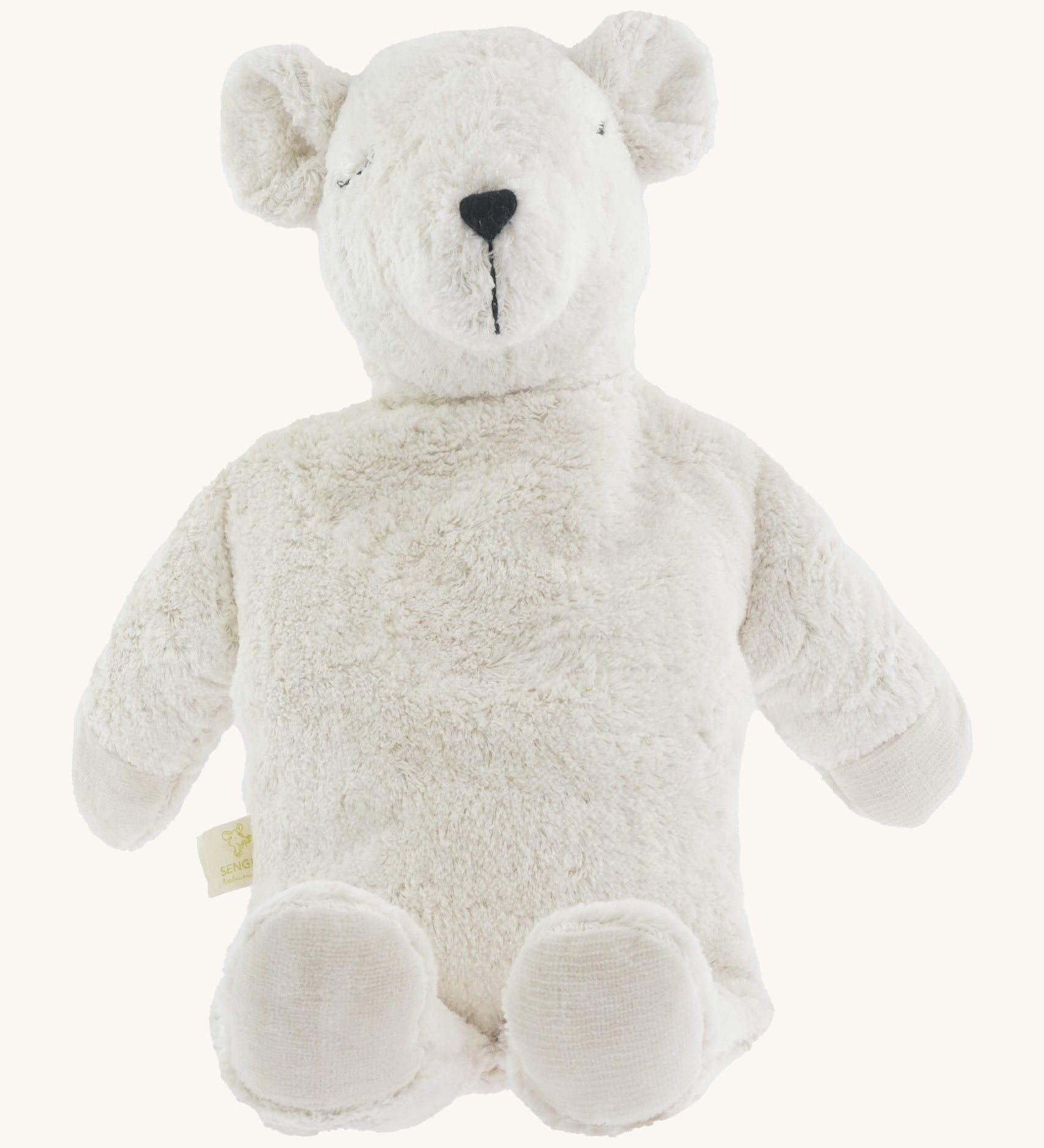 A large soft cuddly white Senger polar bear toy sitting on a cream background. 