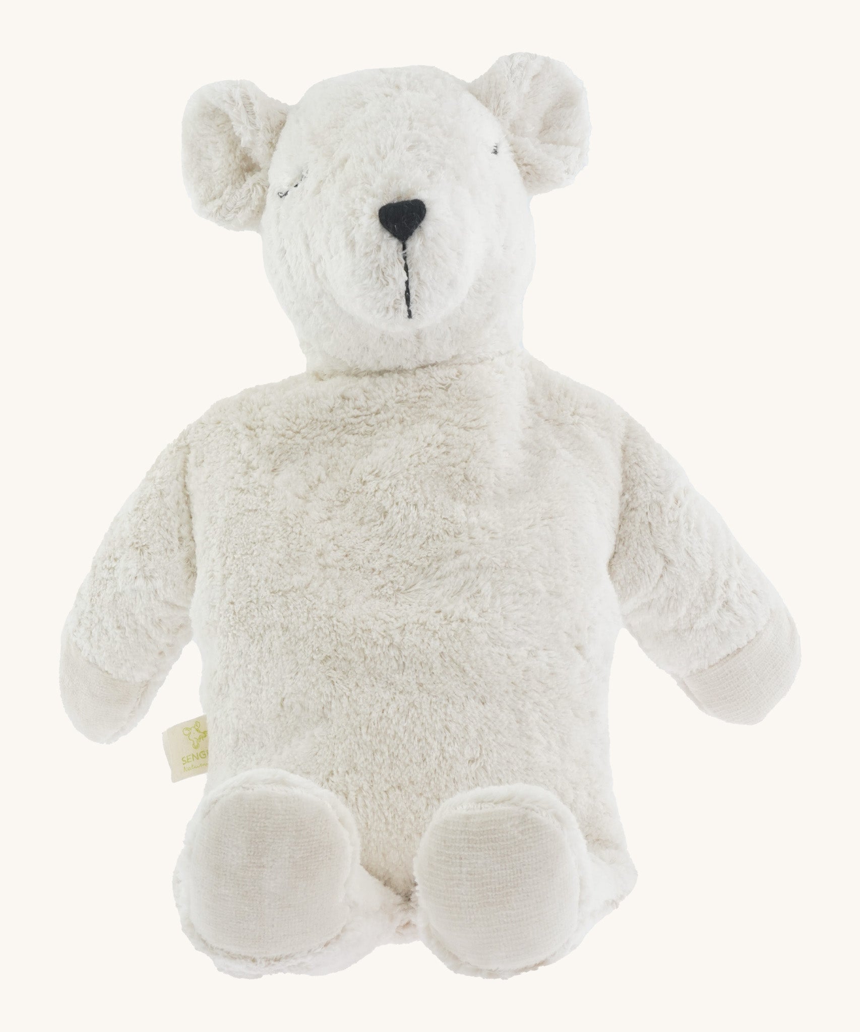 A large soft cuddly white Senger polar bear toy sitting on a cream background. 