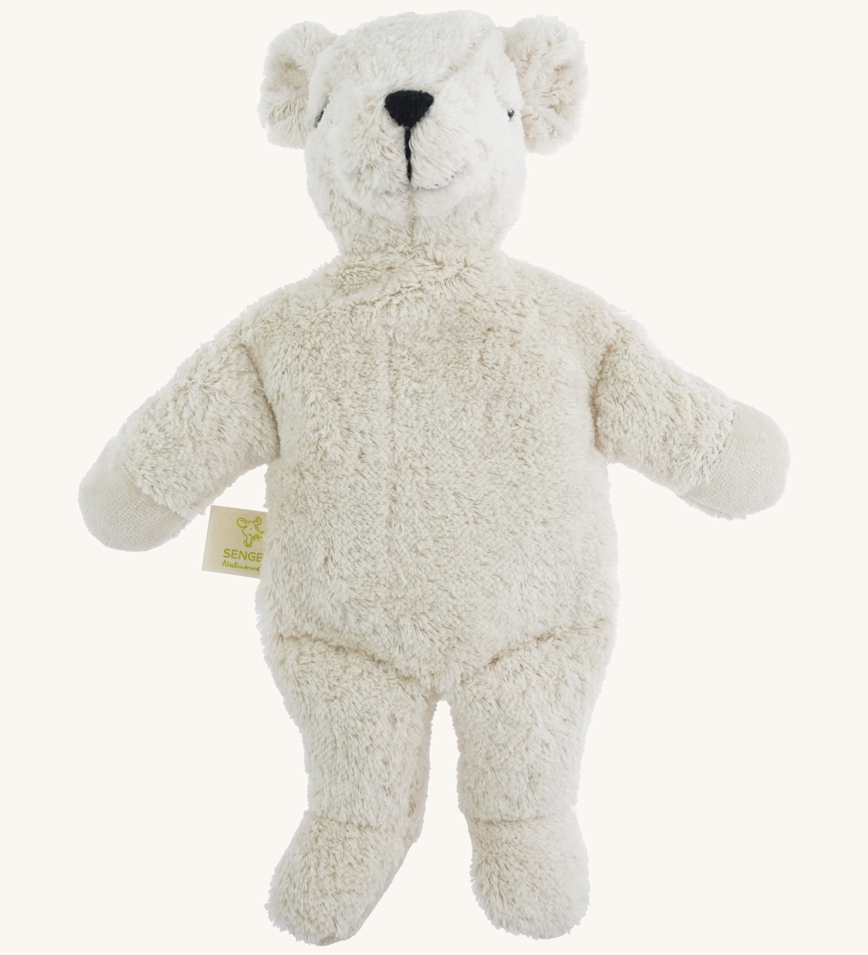 A small soft cuddly white Senger polar bear toy on a cream background. 