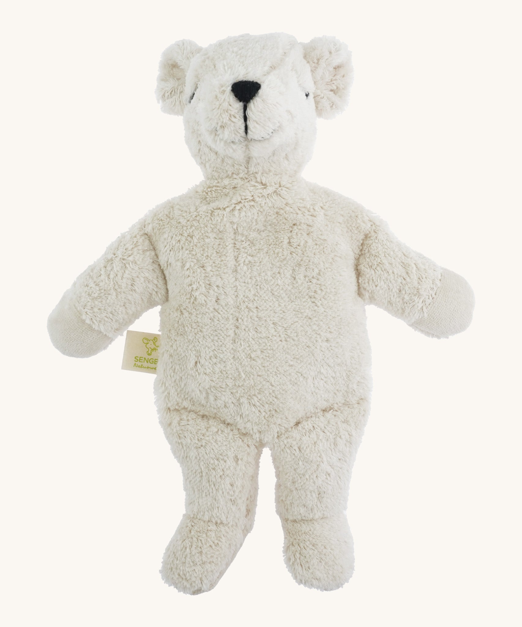 A small soft cuddly white Senger polar bear toy on a cream background. 