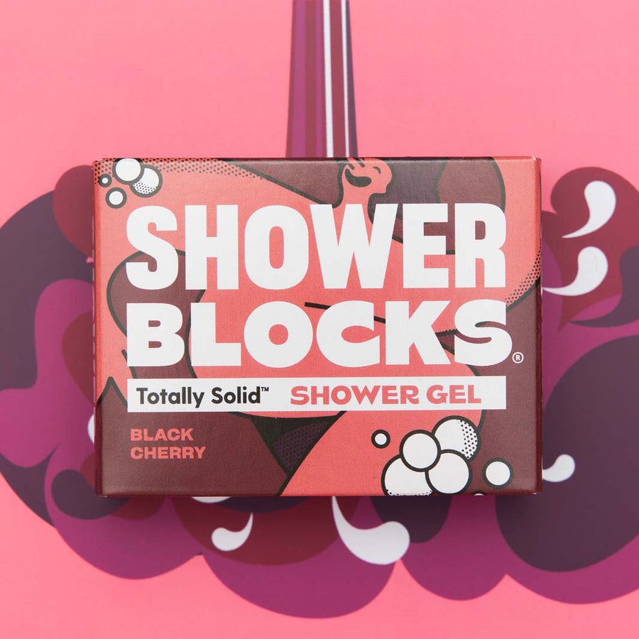 A Shower Blocks Black Cherry fragranced plastic free Gel Bar in it's box pictured on a pink and purple coloured patterned background