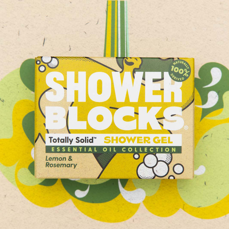 A Shower Blocks essential oil collection lemon & rosemary fragranced plastic free Gel Bar in it' s box pictured on a yellow and green coloured background