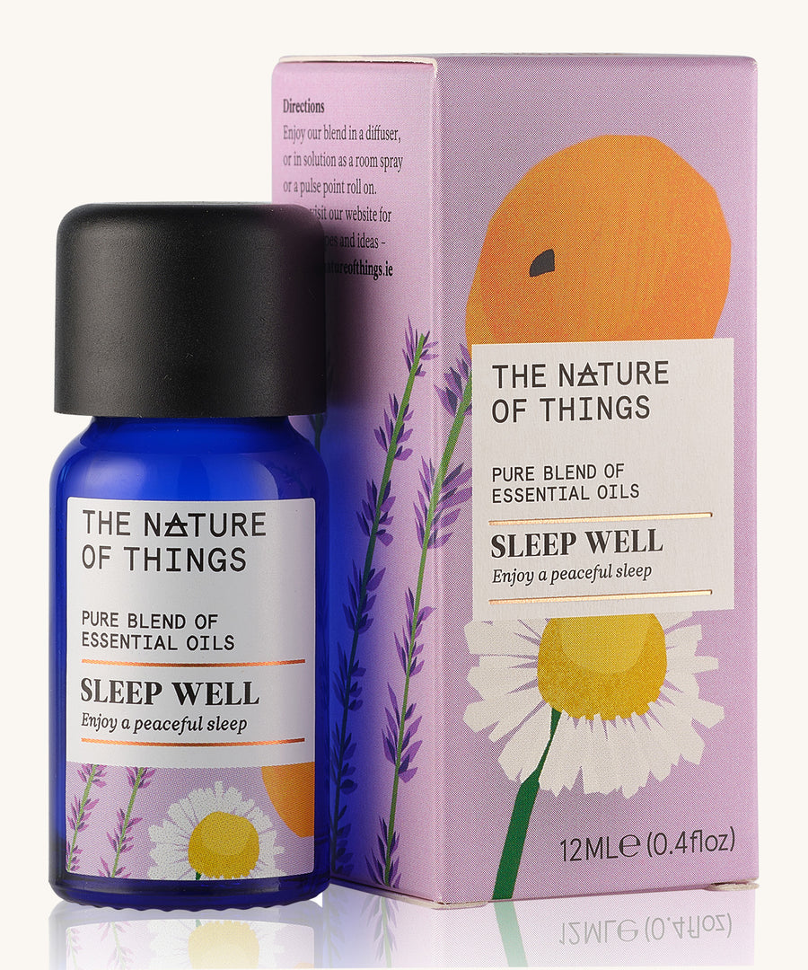 Sleep Well pure essential oil blend in a blue glass bottle in front of a decorative pink cardboard box.