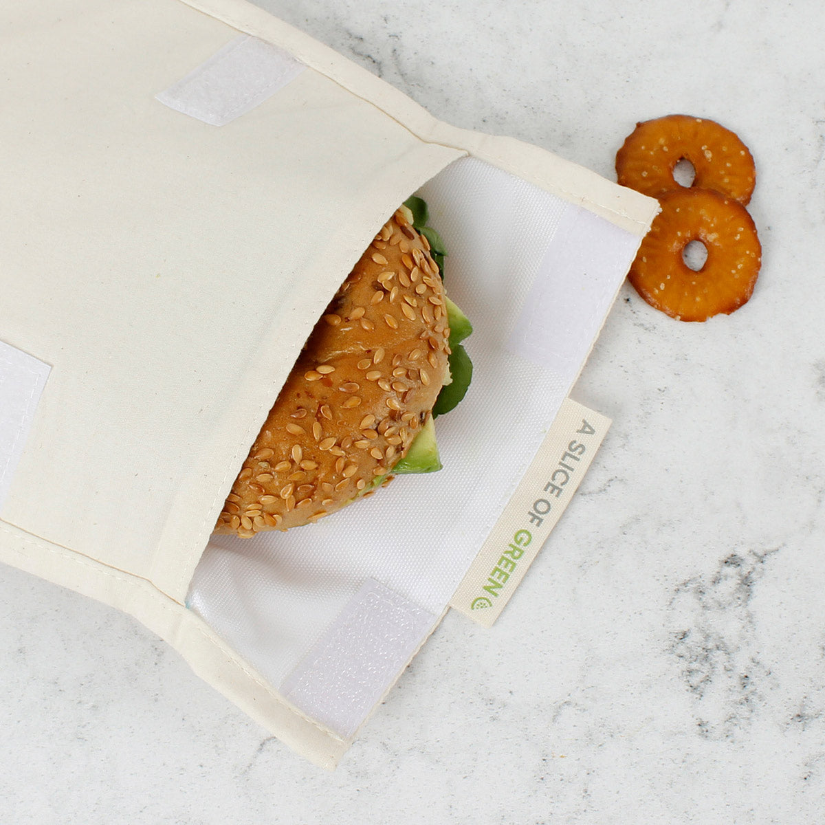 Close up of a bagel inside the A Slice of Green reusable velcro food storage baggie