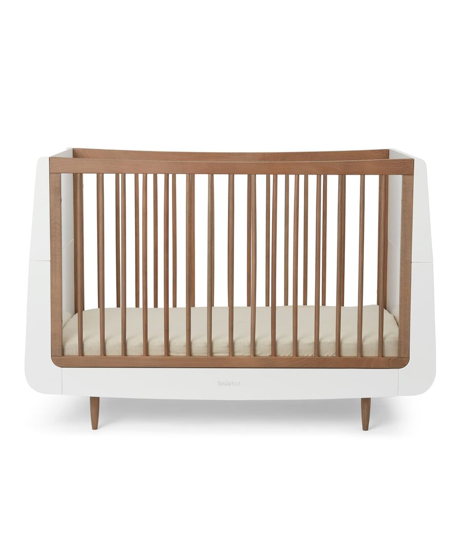 A SnuzKot Cot bed in walnut pictured on a plain background 