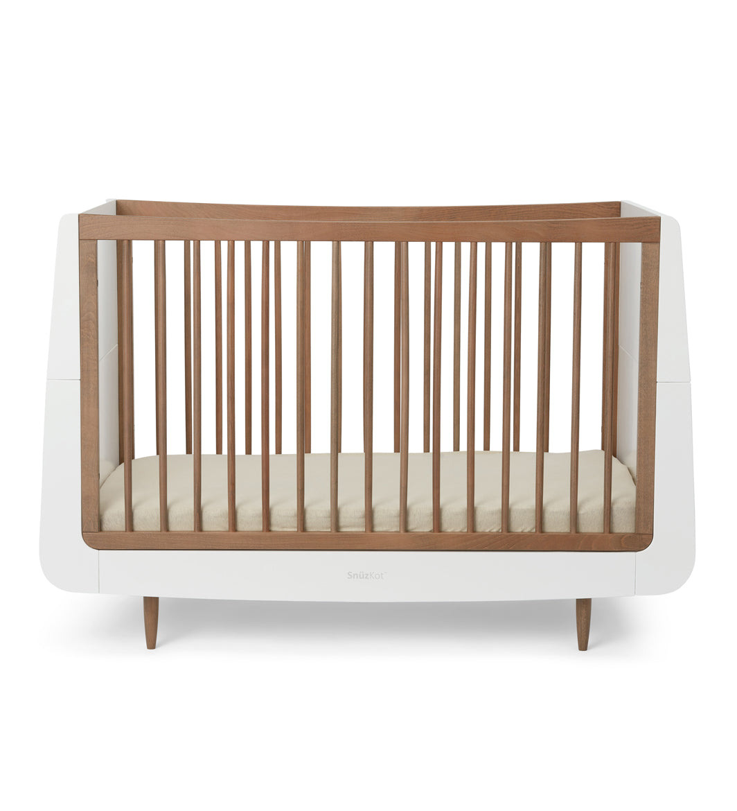 A SnuzKot Cot bed in walnut pictured on a plain background 