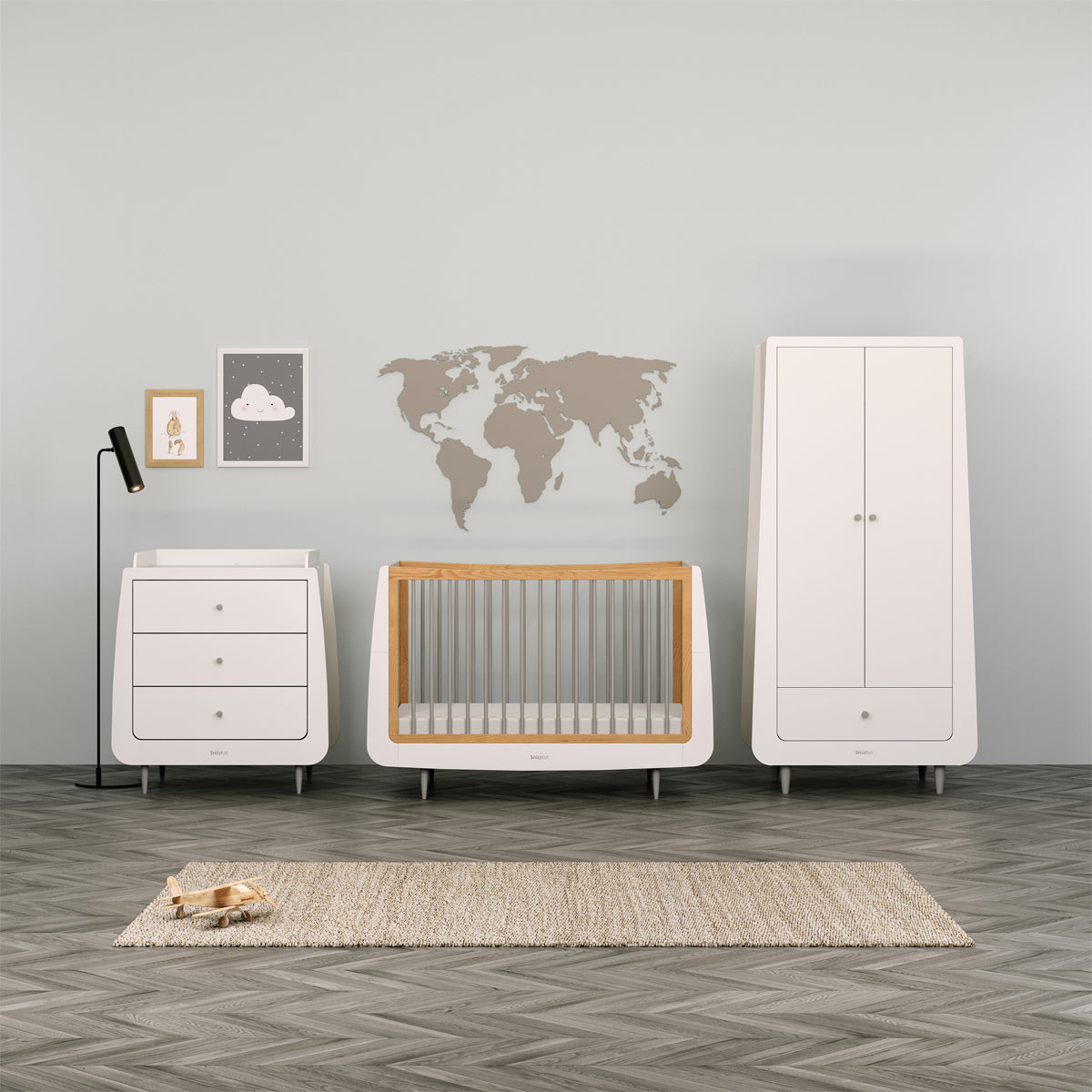 A collection of skandi grey SnuzKot Furniture set up in a nursery. A changing unit, cot bed and a wardrobe can be seen in front of a light green coloured wall