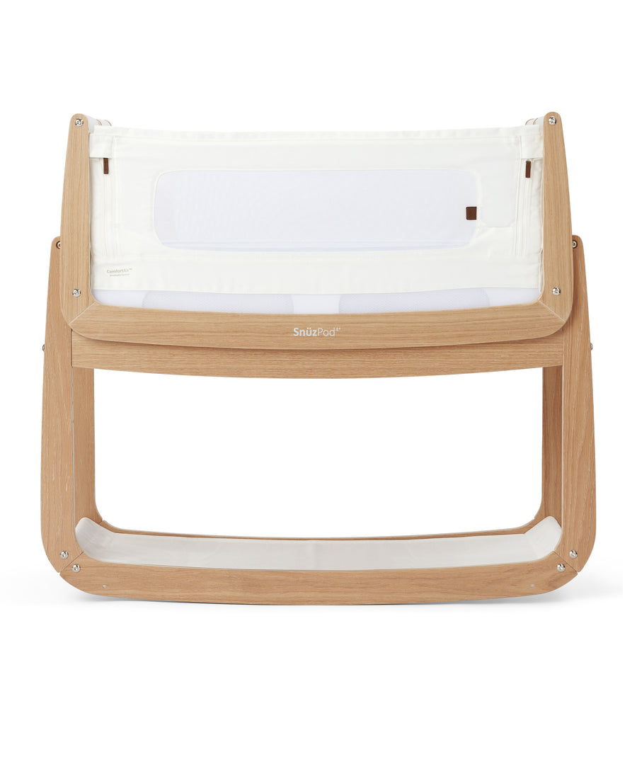 An oak Snuzpod4 bedside crib from the Natural Edit collection pictured on a plain background