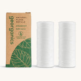 A pair of Georganics spearmint floss refills with the cardboard box on a cream background 