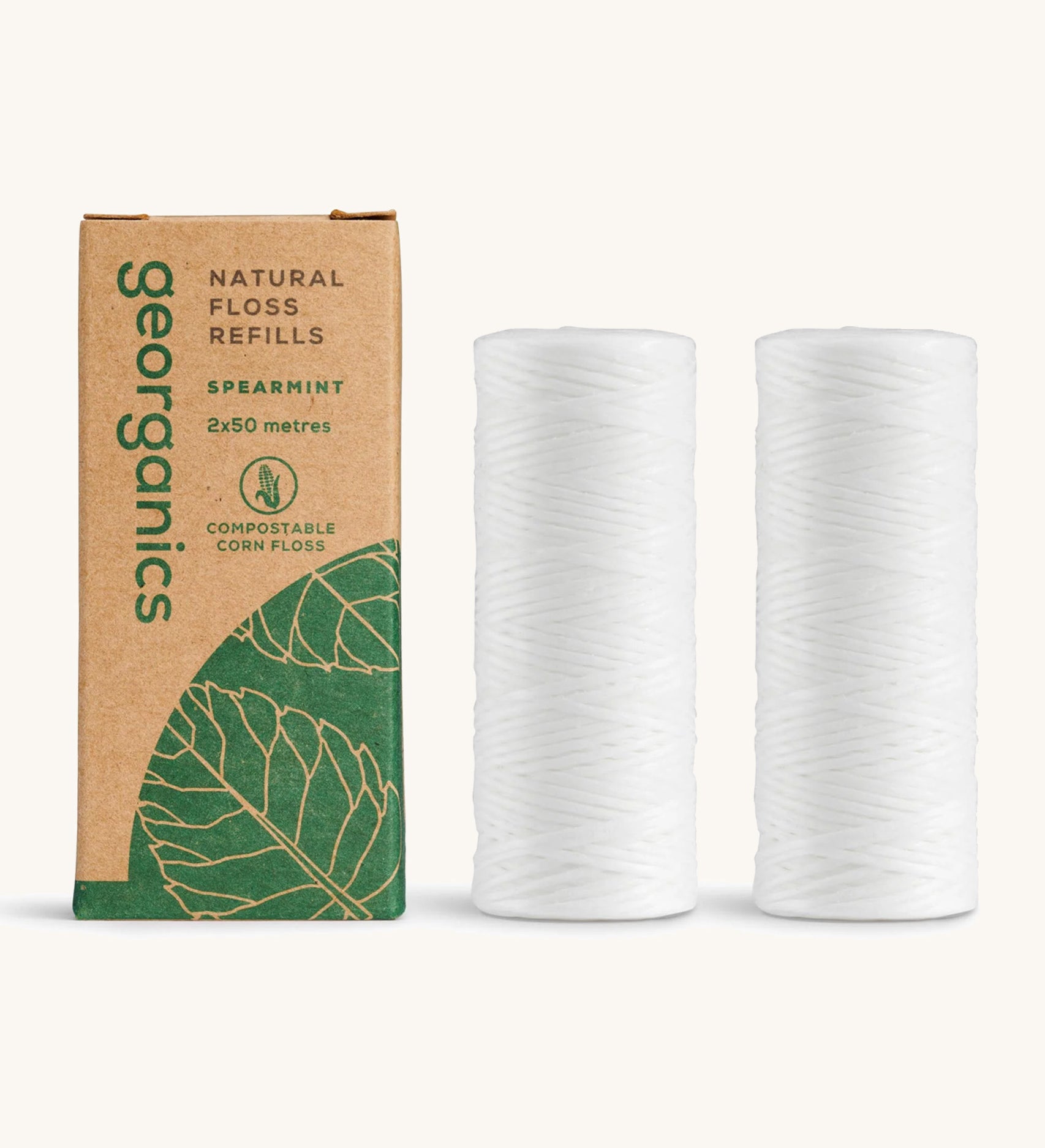 A pair of Georganics spearmint floss refills with the cardboard box on a cream background 