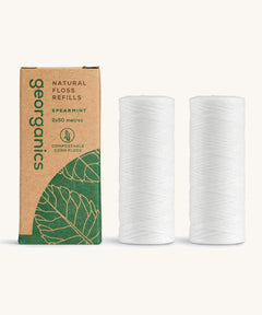 A pair of Georganics spearmint floss refills with the cardboard box on a cream background 