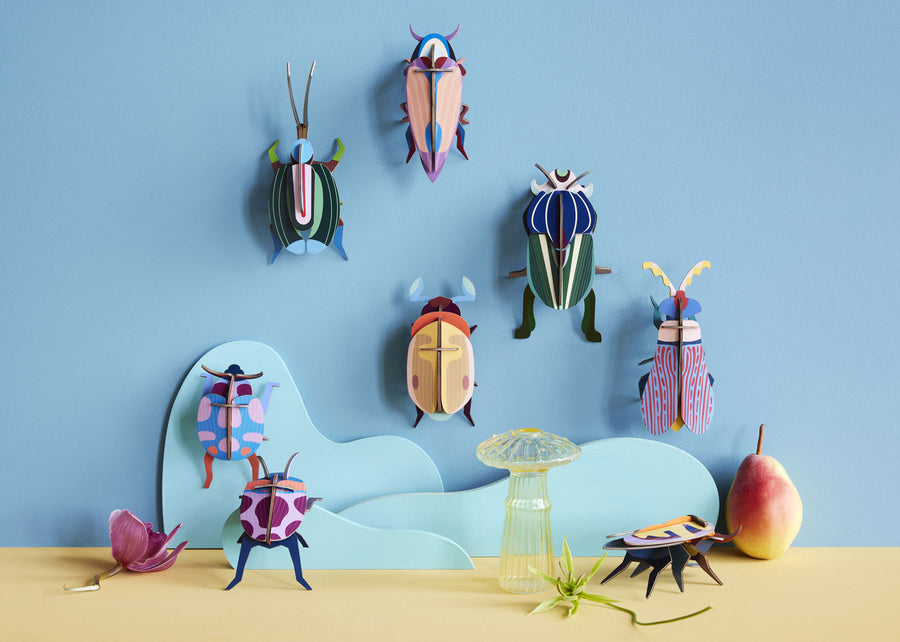 collection of Studio Roof insects and bugs hung up on a blue coloured wall