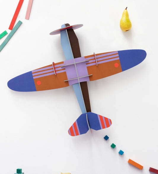 a cardboard model plane with geometric patterns and bright colours