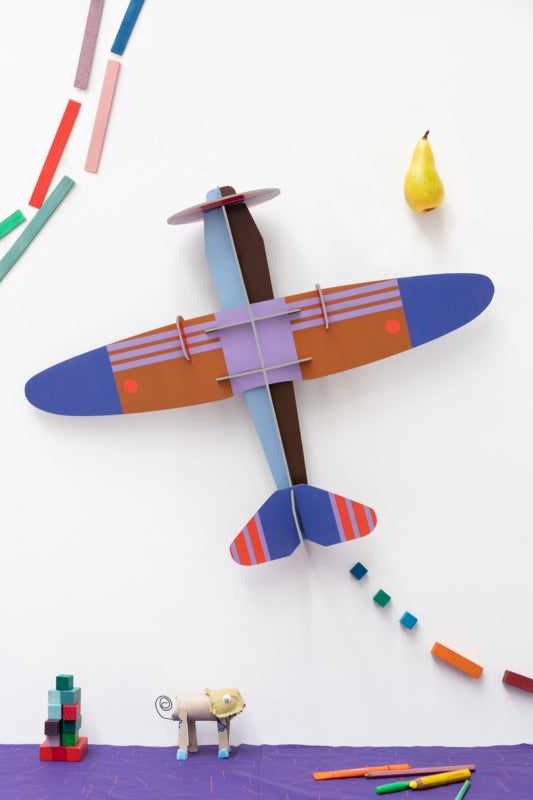 a cardboard model plane with geometric patterns and bright colours