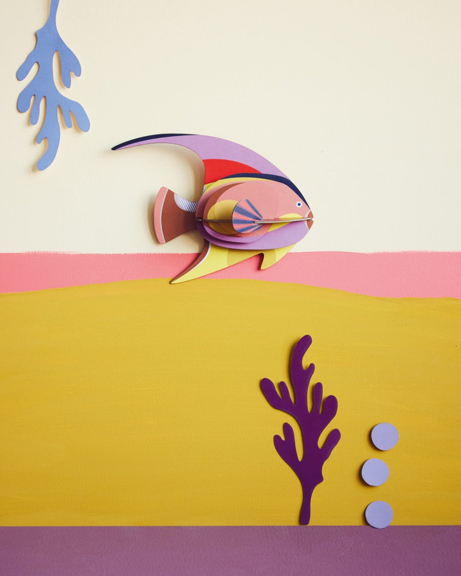 Studio Roof card craft fish on a pink and yellow wall next to some card plants