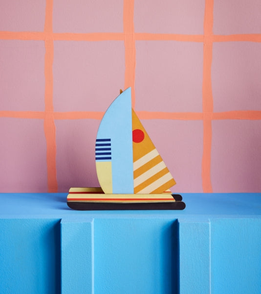 a cardboard model boat with geometric patterns and bright colours