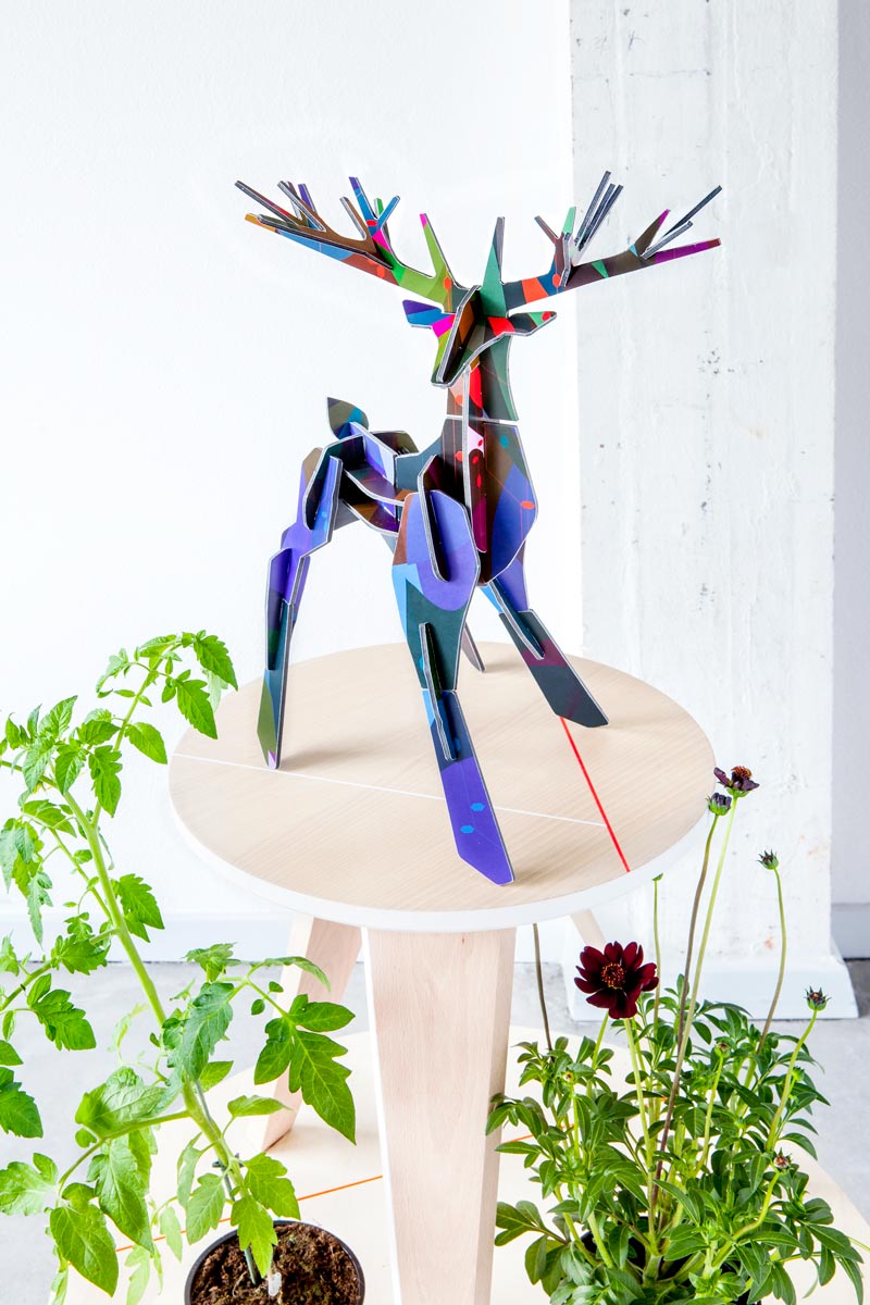 Studio roof totem stag slotting animal model stood on a wooden table above some green plants