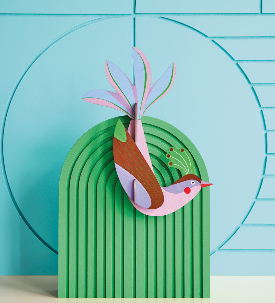 Studio roof eco-friendly maui bird card model attached to a green stand in front of a blue patterned wall