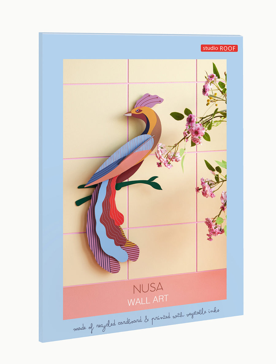 Studio Roof Nusa Bird of Paradise sitting on a green tree branch