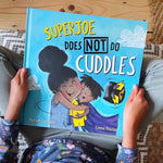 Superjoe does not do cuddles kids book by michael catchpool open on a white background