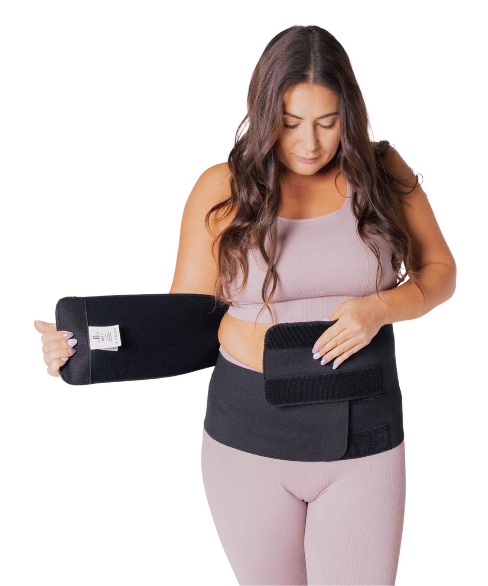 A person wearing a pink outfit, showing how to put on the Lola & Lykke Core Restore Postpartum Belly Band