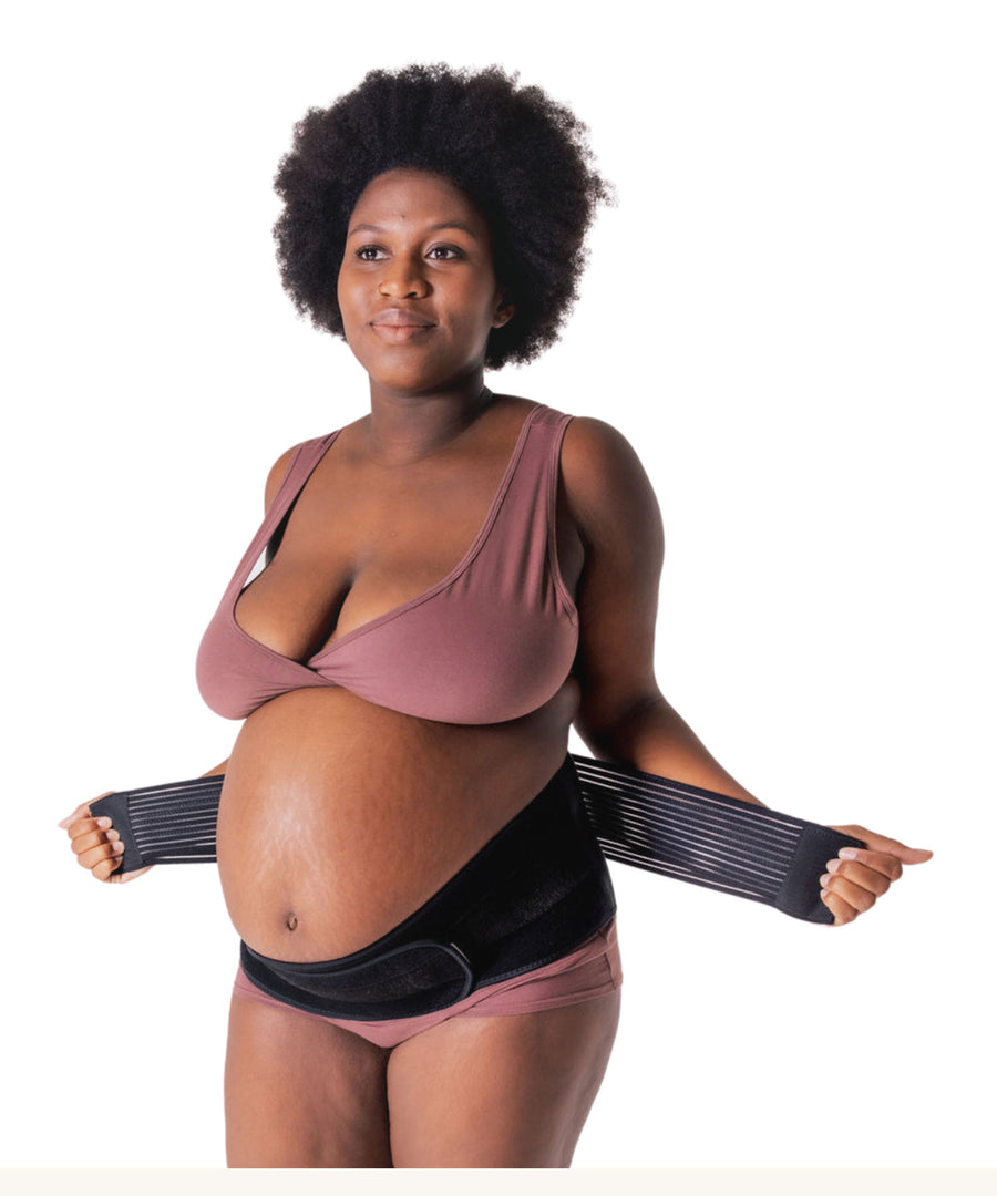 A person showing how to put on the Lola & Lykke Core Relief Pregnancy Support Belt