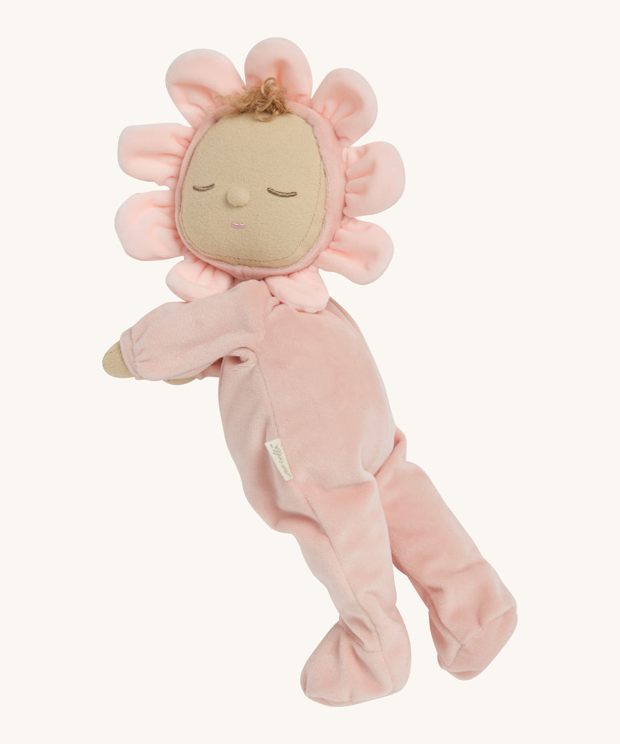 A light pink dozy dinkum doll lying down on a cream background.