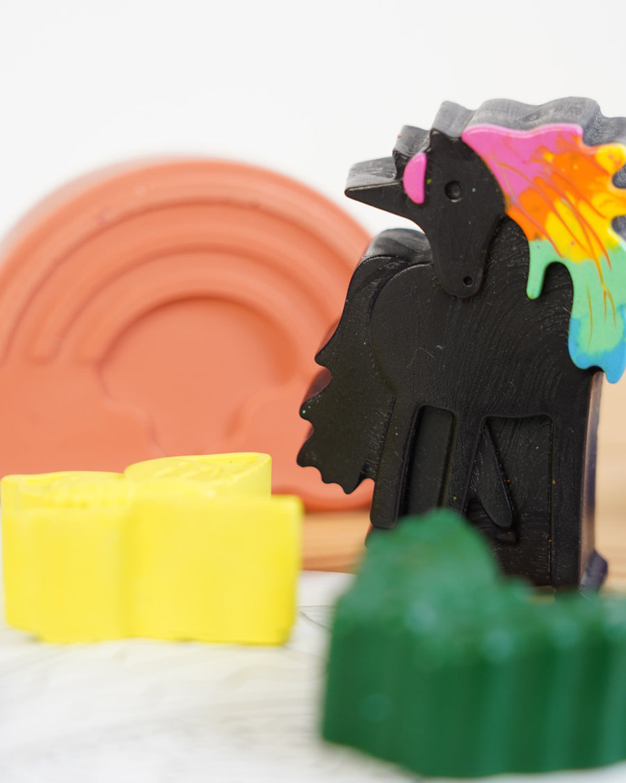 Close up of a black wax unicorn from the crayon bug unicorn dreams pack on a white background