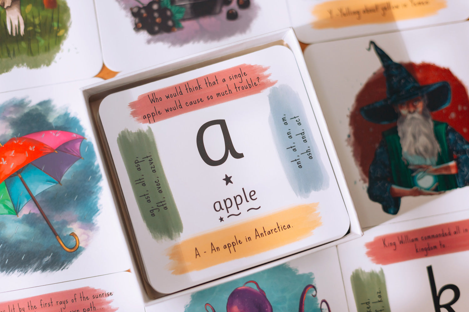 The Phive Enchanting Learning Phonics & Storytelling Cards - Set 1 card laid out with the box on top with a card with the letter a for apple on the top