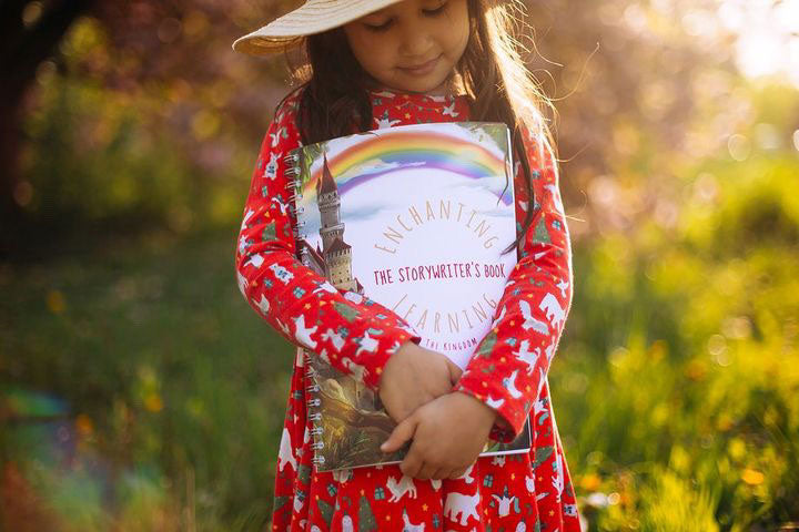 A child holding the The Phive Enchanting Learning Storywriter's Book - The Kingdom