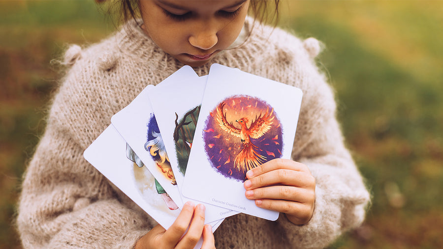 Child holding up four The Phive magical storytelling cards