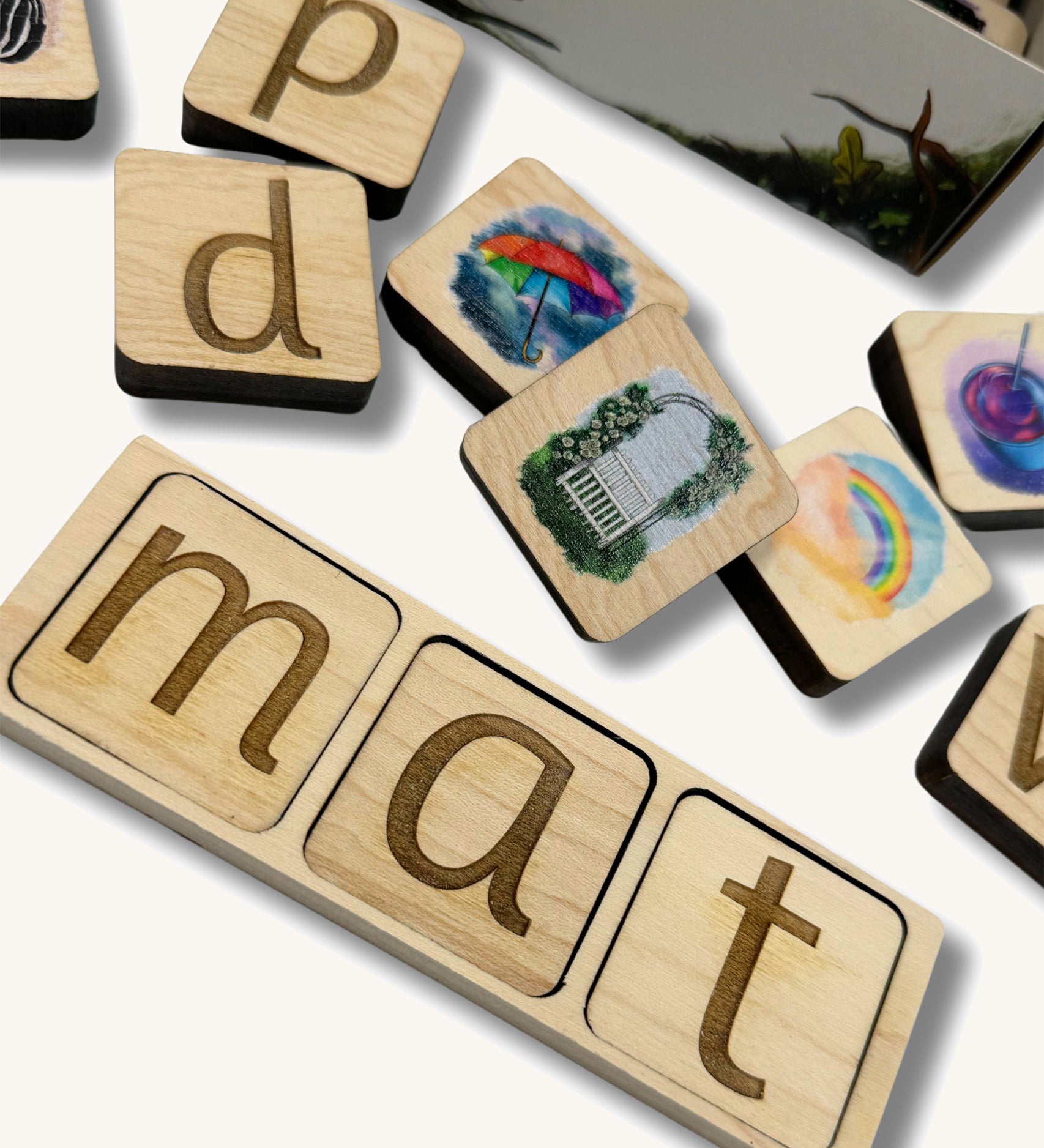 A close of the lettered phonic tiles with pictured phonic tiles scattered around