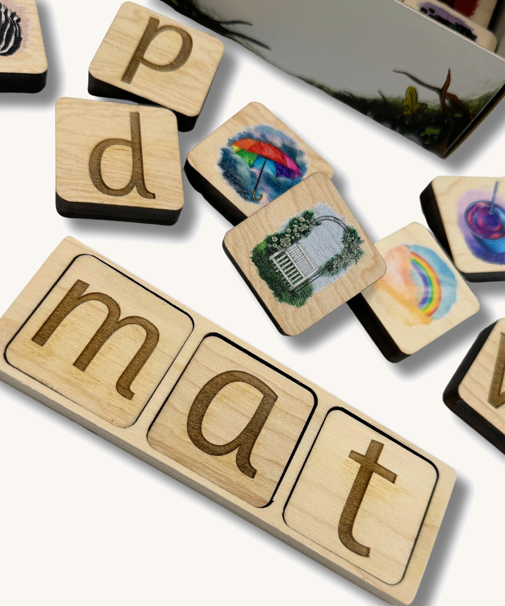 A close of the lettered phonic tiles with pictured phonic tiles scattered around