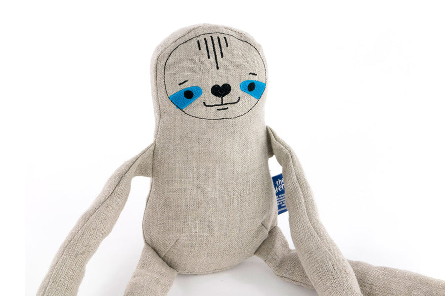 Close up of the Tobe hempions sloth toy on a white background