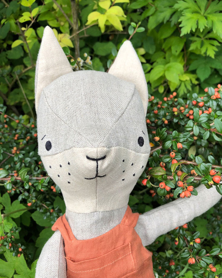 Close up of the Tobe hempions fox toy in a small tree surrounded by red berries