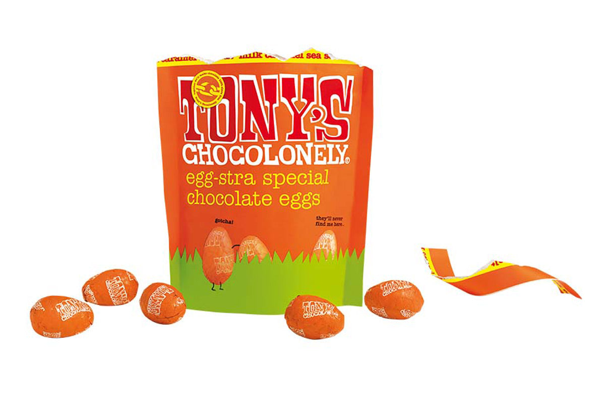 Tony's chocolonely eco-friendly caramel sea salt mini chocolate eggs pouch open on a white background next to some orange chocolate eggs