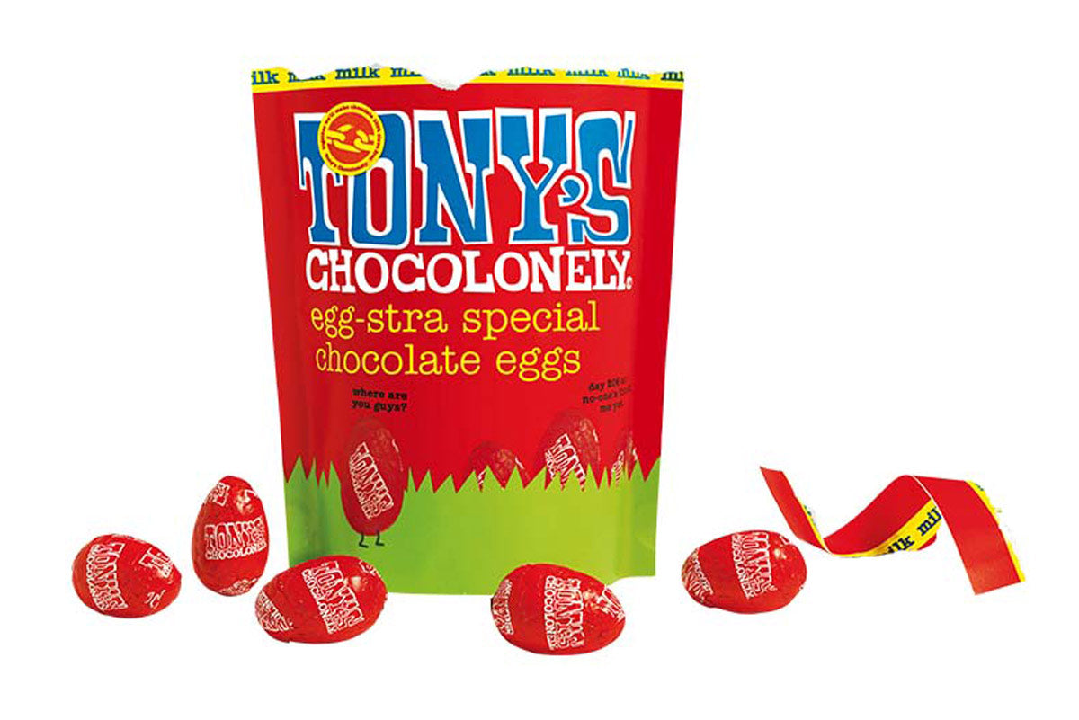 Tony's chocolonely fairtrade mini milk chocolate easter eggs share bag open on a white background next to some red chocolate eggs