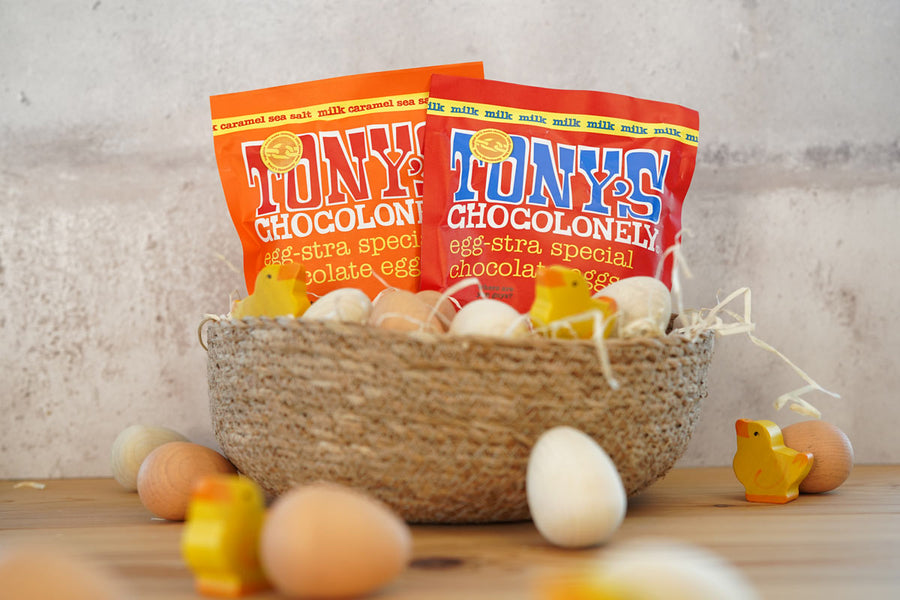 Tonys chocolonely eco-friendly mini easter egg pouches in a basket surrounded by small wooden eggs and chick toys